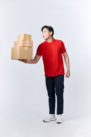 Asian man holding package parcel box isolated on white backgroundの写真素材