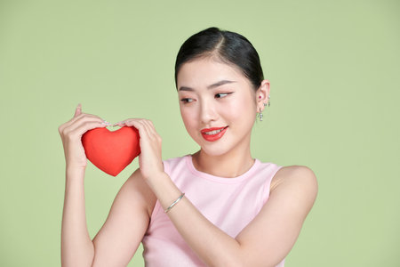 pretty lady holding little paper heart postcards making boyfriend surprise date invitationの写真素材