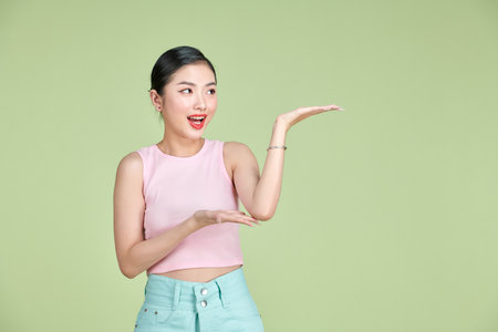 Smiling woman showing open hand palm with copy space for product or textの写真素材