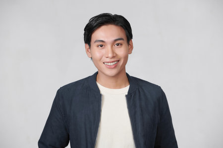 Confident young man standing with crossed arms isolated on whiteの写真素材