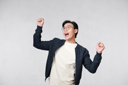 Portrait of a satisfied young man celebrating success isolated over white backgroundの写真素材