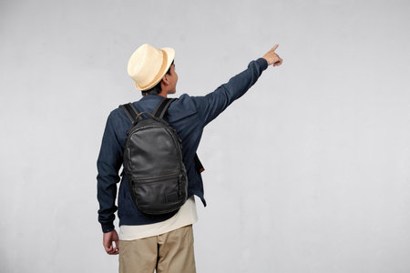 rear view of male hiker with backpack isolated on white backgroundの写真素材