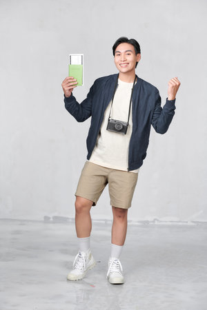 Asian tourists holding passports and enjoying holidays Isolated on blue background.の写真素材