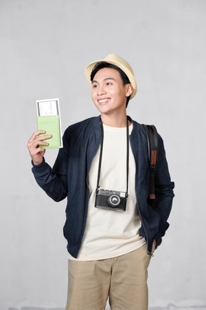 Man waiting at an airport, holding tickets, isolated in whiteの写真素材