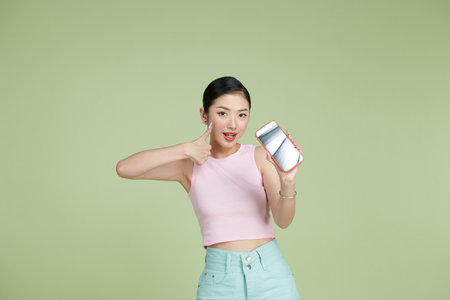 A charming beautiful attractive lady taking photo offering suggesting advising product raising her thumb upの写真素材