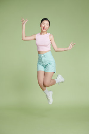 Full length body size photo woman surprised amazed jumping up happy overjoyedの写真素材