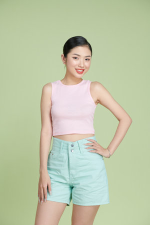 Full lenght of charming young girl hand hip isolated over green light backgroundの写真素材