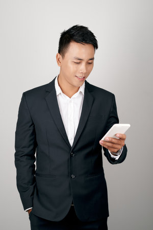 a young man using a cellphone isolated on white backgroundの写真素材