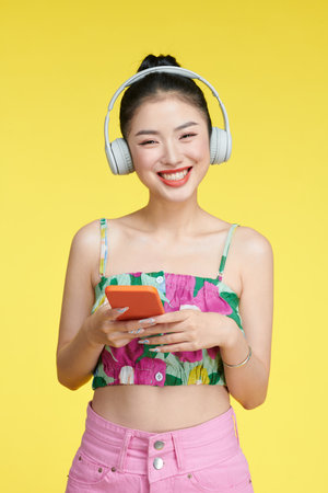 Young woman dancing while listening music with headphones and cellphoneの写真素材