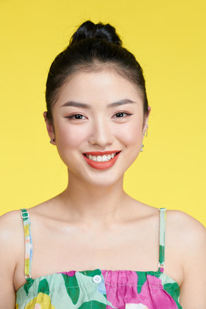 Beautiful healthy woman smiling on yellow background portraitの写真素材