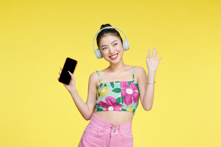 Young woman dancing while listening music with headphones and cellphoneの写真素材