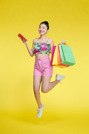 Full length photo of pretty positive lady hold store mall packages use telephoneの写真素材
