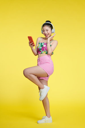 optimistic carefree woman dances with rhythm of music wears stereo headphones enjoys favorite songの写真素材