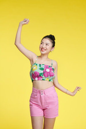 Happy attractive woman dancing and having fun, raising hands up carefree,の写真素材