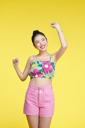 Happy attractive woman dancing and having fun, raising hands up carefree,の写真素材