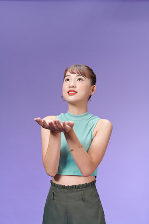 Young pretty woman holding something with hands, showing a product,の写真素材