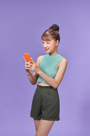 Smiling young woman girl posing isolated on purple pastel wall background studio portraitの写真素材