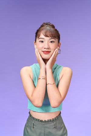 Happy beautiful woman holding her cheeks looking at camera.の写真素材
