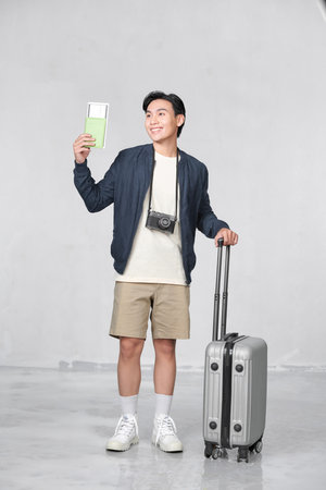 Asian ipster man holding passport and ticketsの写真素材
