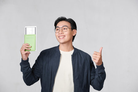 Asian ipster man holding passport and ticketsの写真素材