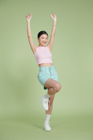 Full-length portrait of amazing asian girl posing with hands upの写真素材