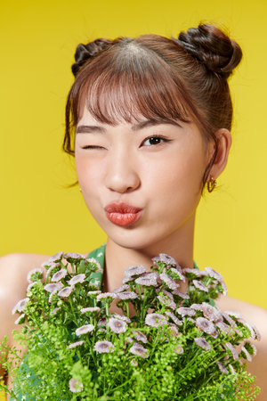 Happy young girl holding bouquet of flowers in her handsの写真素材