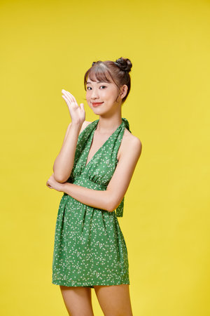 Sexy carefree woman posing near yellow wall in studioの写真素材
