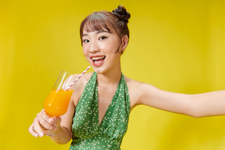 Summer portrait of beautiful Asian woman holding fruit juice drinkの写真素材