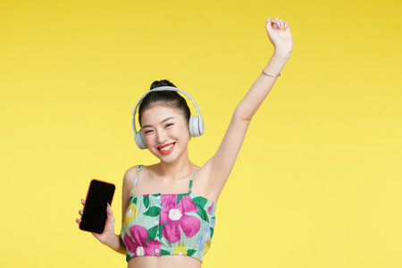 optimistic carefree woman dances with rhythm of music wears stereo headphones enjoys favorite songの写真素材