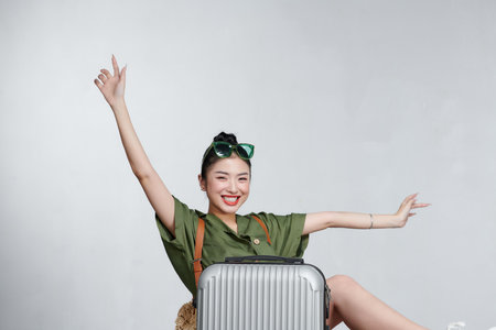 Asian women tourists she is sitting at the airport. She uses a mobile phone.の写真素材