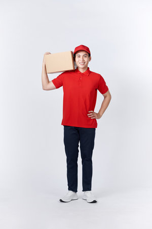 Asian delivery man or passenger holding a cardboard box ready to deliveryの写真素材