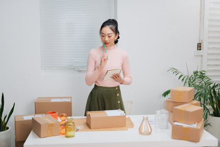 Start up entrepreneur of young asian woman working with box for packaging order for business online and online shopping.の写真素材