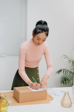 Young pretty asian entrepreneur warehouse worker working and checking product inventory in warehouse showroom.の写真素材
