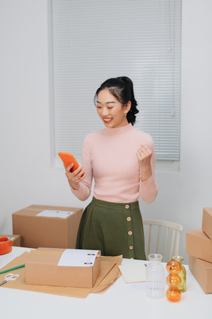 Female online store preparing an order for shipping in a warehouseの写真素材