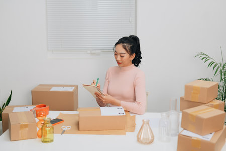 female online store small business owner seller entrepreneur packing package post shipping box preparing delivery parcel.の写真素材