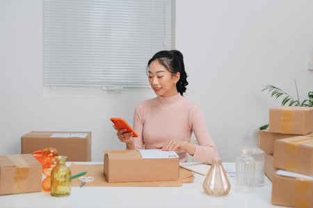 Young beautiful woman checking a parcel, with smiling look happy with her jobの写真素材
