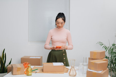 Business woman taking a picture of a package box with her smartphone.の写真素材