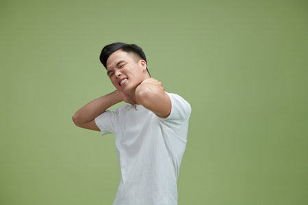 Young man suffering from neck pain, horizontalの写真素材