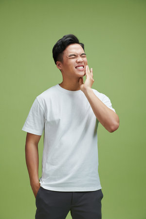 man feel toothache with green background, asianの写真素材