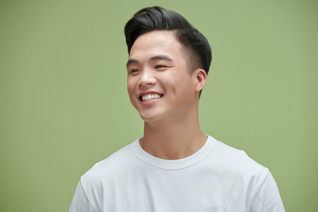 Image of young Asian man posing on backgroundの写真素材