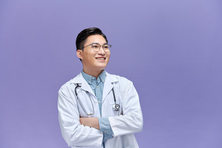 portrait of young asian doctor isolated on purple backgroundの写真素材