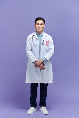 Doctor with arms folded wearing breast cancer awareness ribbonの写真素材
