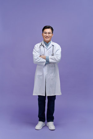 Portrait of young Asian male doctor on purple backgroundの写真素材