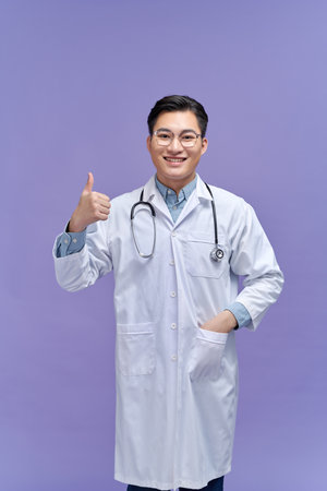 Portrait of a friendly doctor smiling giving thumbs upの写真素材