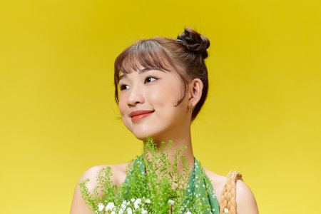 Beautiful Woman with Clean Fresh Skin holding flowersの写真素材