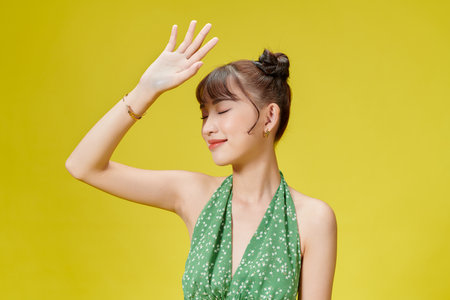 Portrait of a beautiful asian girl covering face by hand of bright sun lightの写真素材