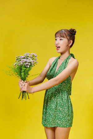 Young girl with large bouquet of small pink wildflowers laughsの写真素材