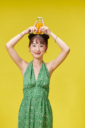 Smiling beautiful woman holding bottle orange juiceの写真素材