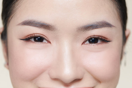 Happy young woman face with clear skin on brown background, closeup portraitの写真素材