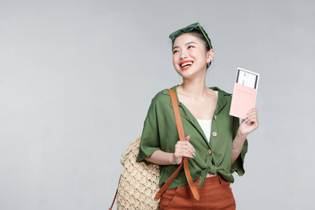 Portrait of a happy smiling young girl holding passport and travelling ticketsの写真素材